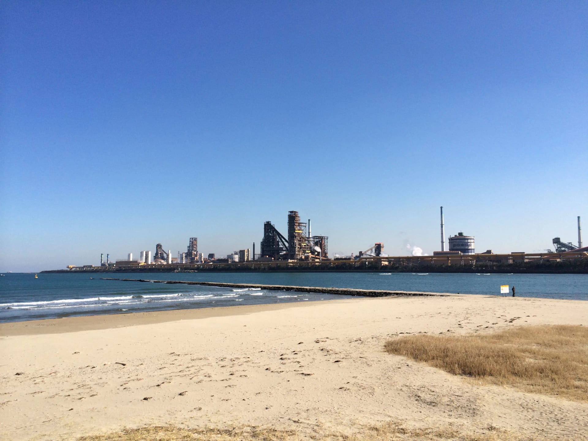 Vista da usina siderúrgica da POSCO em Pohang, na Coreia do Sul, com suas chaminés ao longo da costa, vista da praia de Songdo