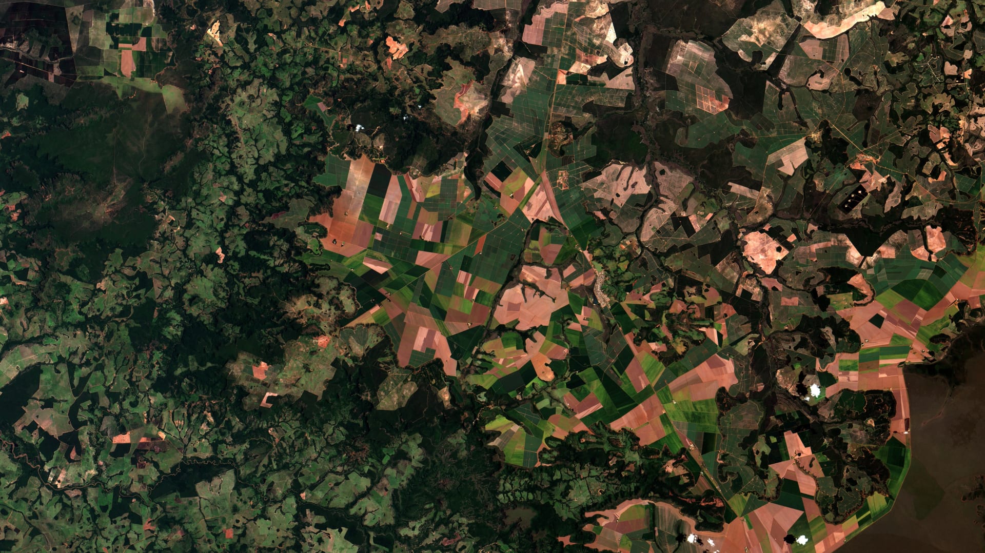 Imagem de satélite de Alto Taquari, no sudeste do Mato Grosso, com lotes agrícolas geométricos em tons de verde e laranja recortados sobre as chapadas do cerrado